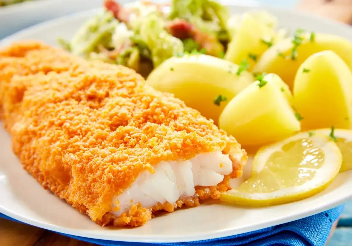Chrupiący filet rybny w panierce, idealny do podania z ziemniakami i cytryną. Dowiedz się, jak smażyć rybę w mące i jajku, by uzyskać taki efekt.