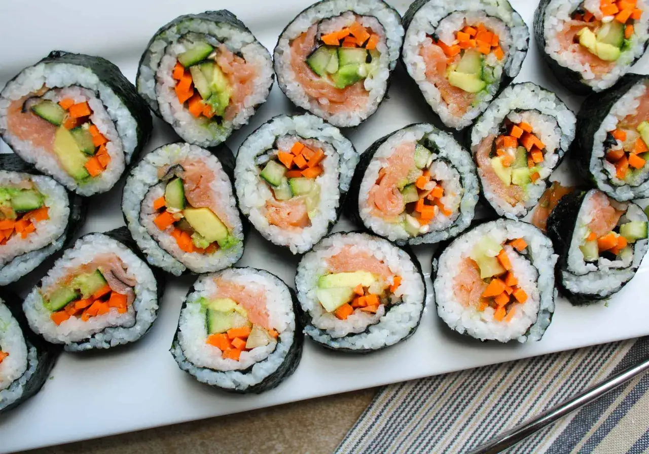 Roladki sushi zawinięte w nori, z łososiem, awokado, ogórkiem i marchewką.