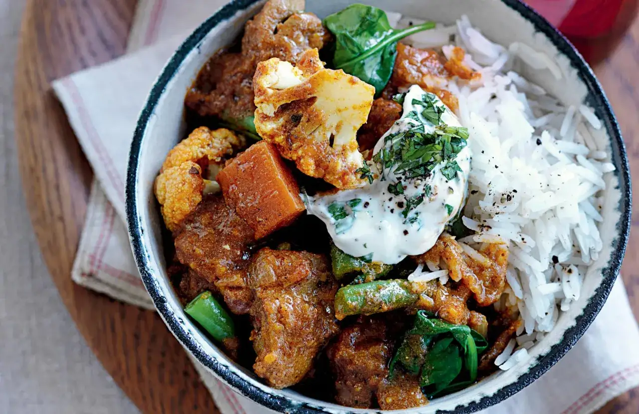 Aromatyczny kurczak curry z warzywami: kalafiorem, fasolką szparagową i szpinakiem, podany z ryżem basmati i jogurtem.