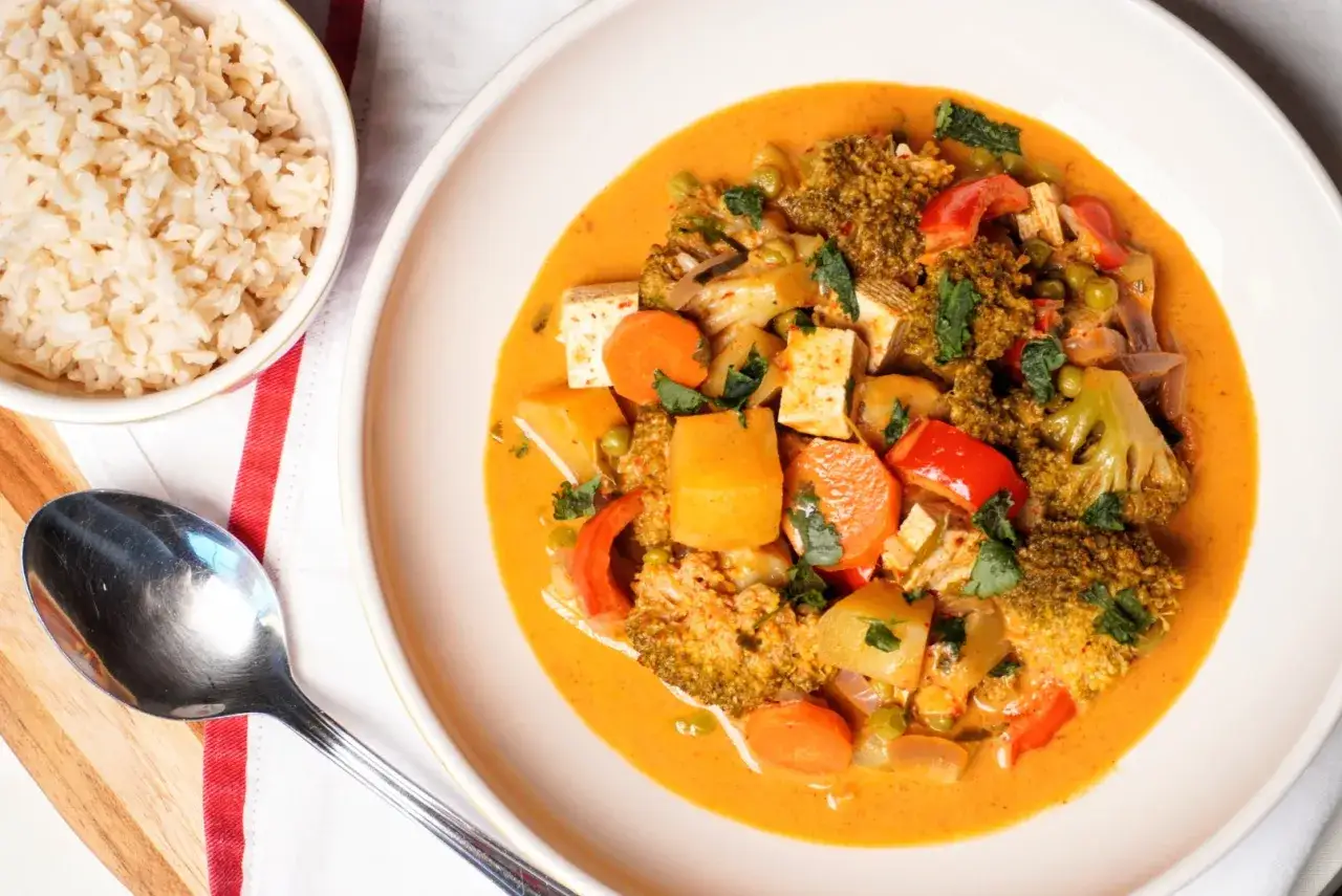 Pyszny, wegetariański massaman curry przepis z tofu, brokułami i marchewką w kremowym sosie. Podany z brązowym ryżem.