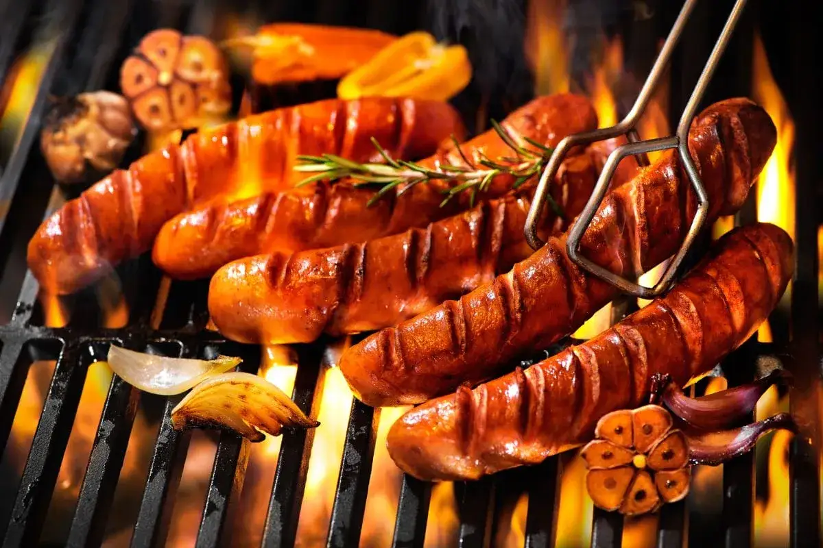Soczyste kiełbaski na grillu, pachnące czosnkiem i rozmarynem. Zastanawiasz się, ile waży jedna kiełbasa? Ta wygląda na solidną porcję!