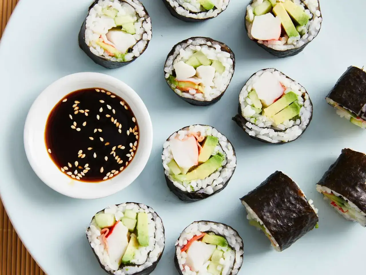 Różne rodzaje sushi z awokado i paluszkami krabowymi, podane z sosem sojowym. Idealne przepisy na domowe sushi.