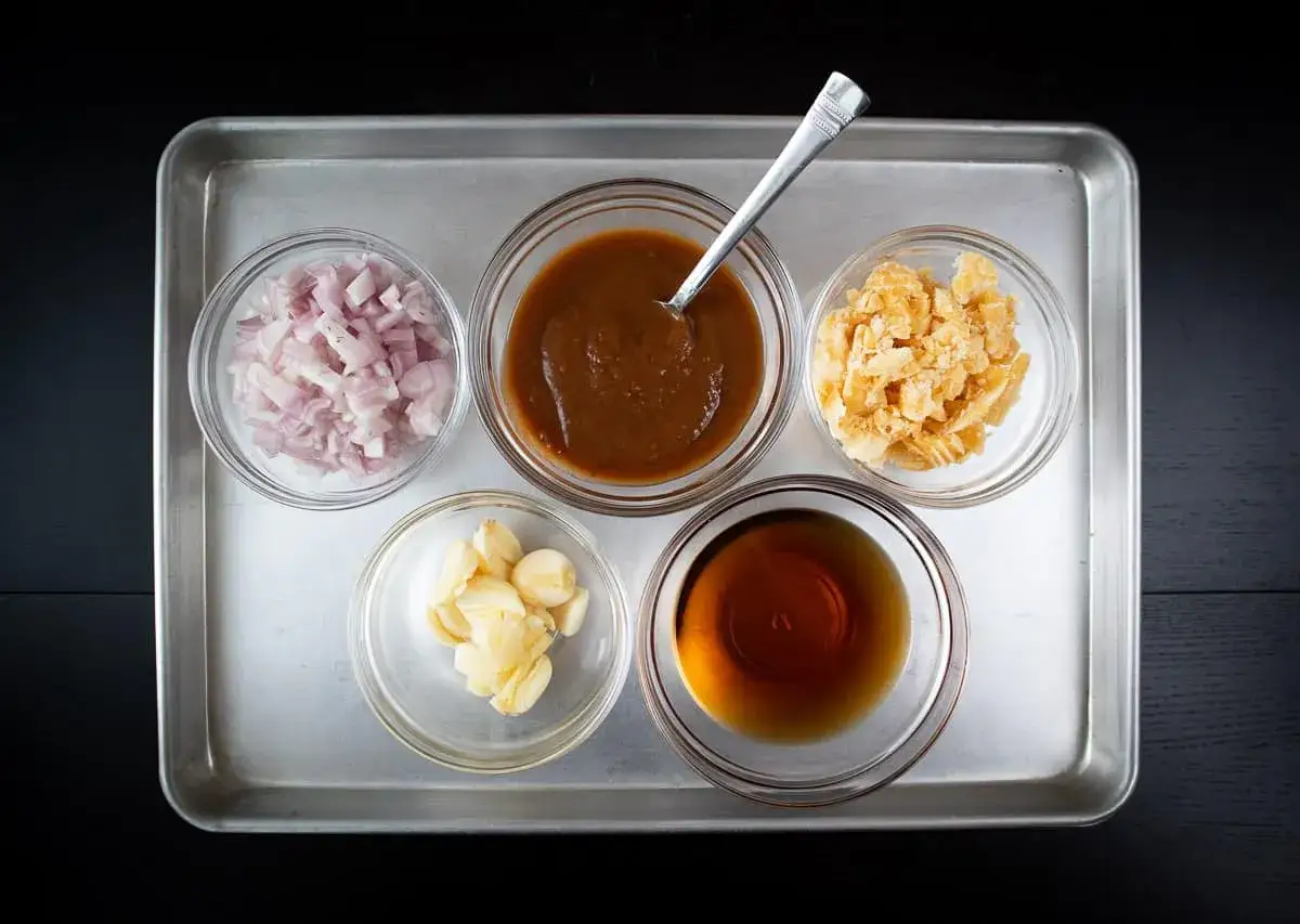 Składniki na sos pad thai: posiekana szalotka, sos tamaryndowy, czosnek, cukier palmowy i sos rybny.