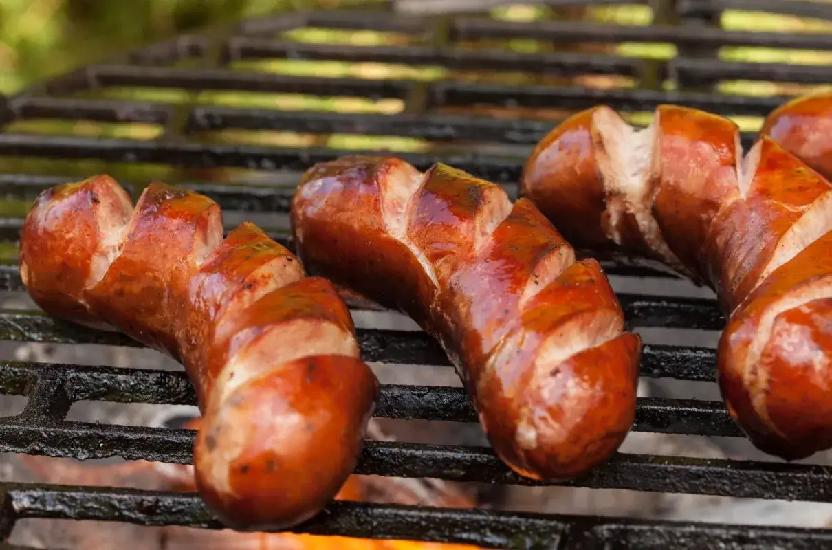 Kiełbaski na grillu, rumiane i soczyste. Zastanawiasz się, ile waży jedna kiełbasa? Ta wygląda na solidną porcję!