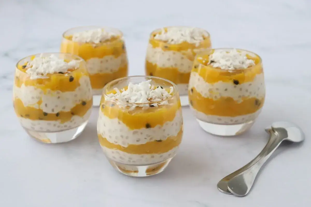 Pięć deserów z tapioki z mango, ułożonych warstwowo, z wiórkami kokosowymi na wierzchu.
