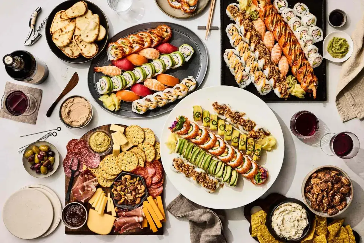Mnóstwo pysznych przekąsek, w tym sushi, wędliny, sery i oliwki, idealne na spotkanie.
