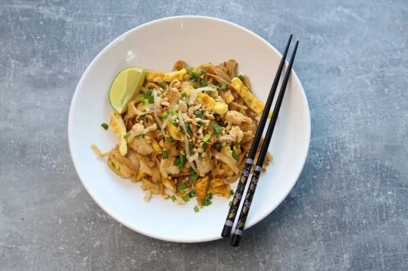 Pyszny pad thai oryginalny przepis z kurczakiem, jajkiem, orzeszkami i limonką.